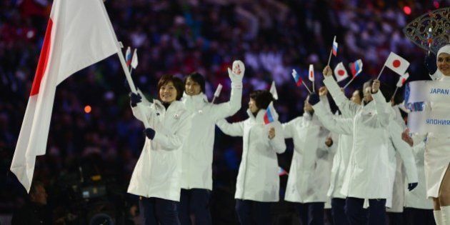 Japan's flag bearer, curler Ayumi Ogasawara, leads her national delegation during the Opening Ceremony of the 2014 Sochi Winter Olympics at the Fisht Olympic Stadium on February 7, 2014 in Sochi. AFP PHOTO / JOHN MACDOUGALL (Photo credit should read JOHN MACDOUGALL/AFP/Getty Images)