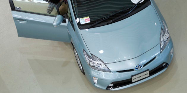 A visitor examines a Toyota Motor Corp. Prius vehicle displayed at the company's showroom in Tokyo, Japan,...