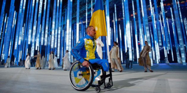 SOCHI, RUSSIA - MARCH 07: Flag bearer Mykailo Tkachenko of the Ukraine enters the arena during the Opening Ceremony of the Sochi 2014 Paralympic Winter Games at Fisht Olympic Stadium on March 7, 2014 in Sochi, Russia. The rest of the Ukraine team refused to enter the arena as a protest against the present political tension between Ukraine and Russia. (Photo by Tom Pennington/Getty Images)
