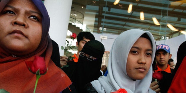 KUALA LUMPUR, MALAYSIA - MARCH 10: Members of a youth group deliver roses and prayers for relatives of passengers onboard Malaysia Airlines flight MH370 at Everley Hotel on March 10, 2014 in Kuala Lumpur, Malaysia. Potential sightings of possible airliner debris and a possible oil slick in the sea off Vietnam have not been officially verified or confirmed as investigative teams continue to search for the whereabouts of missing Malaysia Airlines flight MG370 and its 293 passengers, travelling from Kuala Lumpur to Beijing. The airliner was reported missing on the morning of March 8 after the crew failed to check in as scheduled. Relatives of the missing passengers have been advised to prepare for the worst as authorities focus on two passengers on board travelling with stolen passports. (Photo by Rahman Roslan/Getty Images)