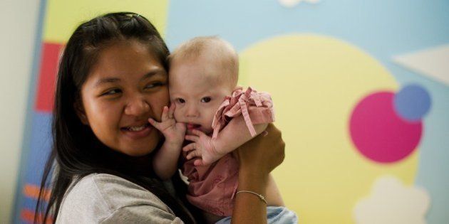 Thai surrogate mother Pattaramon Chanbua (L) holds her baby Gammy, born with Down Syndrome, at the Samitivej hospital, Sriracha district in Chonburi province on August 4, 2014. The surrogate mother of a baby reportedly abandoned by his Australian parents in Thailand because he has Down Syndrome was a 'saint' and 'absolute hero', Australian Immigration Minister Scott Morrison said. AFP PHOTO / Nicolas ASFOURI (Photo credit should read NICOLAS ASFOURI/AFP/Getty Images)