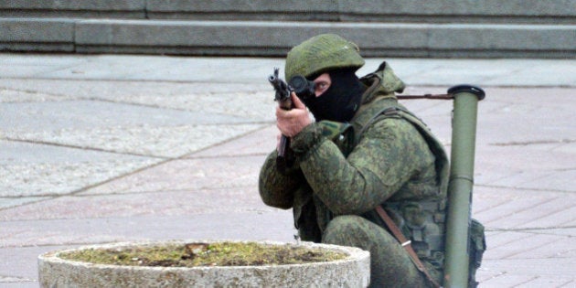 SIMFEROPOL, UKRAINE - MARCH 1: Unidentified gunmen wearing camouflage uniforms stand guard on the street in town on March 1, 2014 in Simferopol, Ukraine. According to media reports Russian soldiers have occupied the airport at nearby Sevastapol while soldiers whose identity could not be initially confirmed have stationed themselves at Simferopol International Airport in moves that are raising tensions between Russia and the new Kiev government. Crimea has a majority Russian population and armed, pro-Russian groups have occupied government buildings in Simferopol. (Photo by Aleksandr Miridonov/Kommersant Photo via Getty Images)