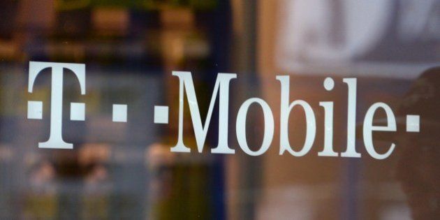A patron exits a T-Mobile store in Glendale, California, on August 1, 2014. Shares in T-Mobile jumped on July 31 on a report that French telecommunications firm Iliad is bidding to buy the US wireless service carrier. AFP PHOTO / Robyn Beck (Photo credit should read ROBYN BECK/AFP/Getty Images)