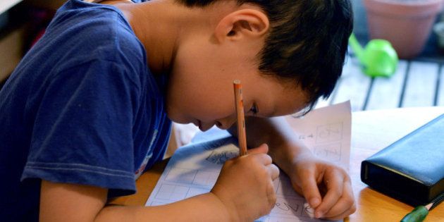THIS IMAGE IS PART OF A PHOTO PACKAGE ON CHILDREN GOING TO SCHOOL AROUND THE WORLDSix-year-old Japanese elemetary student Seishi Nishida does his school work at home in Tokyo on June 10, 2013. AFP PHOTO / Yoshikazu TSUNO (Photo credit should read YOSHIKAZU TSUNO/AFP/Getty Images)