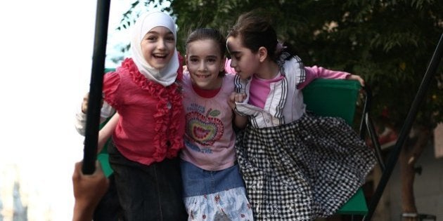 Syrian children enjoy a swing on the first day of Eid-al-Fitr, which marks the end of the Muslim holy month of Ramadan, on July 28, 2014 in the besieged town of Douma, near Damascus. Six children were among at least 15 civilians killed in overnight bomb attacks by government and rebel forces in the divided city of Aleppo, the Syrian Observatory for Human Rights said. AFP PHOTO / ABD DOUMANY (Photo credit should read ABD DOUMANY/AFP/Getty Images)