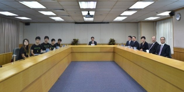 CORRECTS NAMES OF HONG KONG STUDENT LEADERSLeaders of the Hong Kong Federation of Students (L-R) Yvonne Leung, Nathan Law, Alex Chow, Lester Shum and Eason Chung, and Hong Kong government representatives (5th R-R) Edward Yau, Rimsky Yuen, Carrie Lam, Raymond Tam and Lau Kong and mediator, Leonard Cheng Kwok-hon (C), chairman of Lingnan University, look on before commencing their long-awaited talks to formally discuss demands raised by student protesters in Hong Kong on October 21, 2014. Hong Kong's leader Leung Chun-ying has said open elections would result in the city's many poor dominating politics, as he ruled out democratic reforms before crucial talks aimed at ending three weeks of protest rallies. AFP PHOTO / Philippe Lopez (Photo credit should read PHILIPPE LOPEZ/AFP/Getty Images)