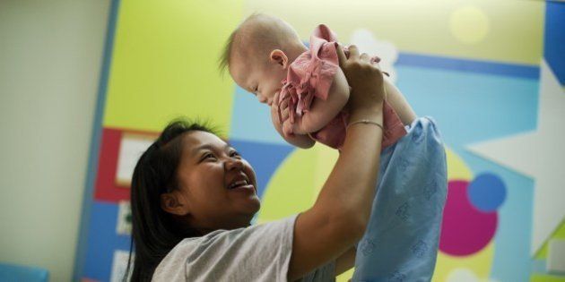 Thai surrogate mother Pattaramon Chanbua (L) with her baby Gammy, born with Down Syndrome, at the Samitivej hospital, Sriracha district in Chonburi province on August 4, 2014. The surrogate mother of a baby reportedly abandoned by his Australian parents in Thailand because he has Down Syndrome was a 'saint' and 'absolute hero', Australian Immigration Minister Scott Morrison said. AFP PHOTO / Nicolas ASFOURI (Photo credit should read NICOLAS ASFOURI/AFP/Getty Images)