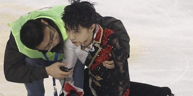 Medical personnel tend to Japanese skater Yuzuru Hanyu (R) on the ice rink after he crashed into Yan Han of China during a practice session before their men's free skating event of the Cup of China ISU Grand Prix of Figure Skating in Shanghai on November 8, 2014. AFP PHOTO CHINA OUT (Photo credit should read STR/AFP/Getty Images)