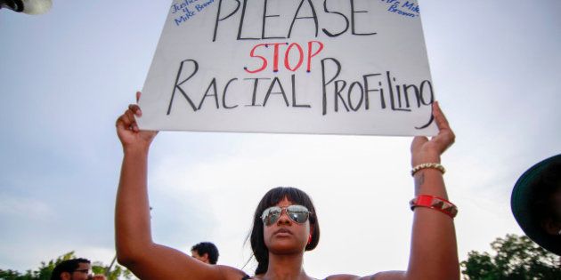 FERGUSON, MO - AUGUST 14: A demonstrator holds up a sign during a rally to protest the shooting death of an unarmed teen by a police officer in Ferguson, Missouri, on August 14, 2014. Eighteen-year-old Michael Brown was shot dead by police in the St. Louis suburb of Ferguson, Missouri on August 09, 2014. (Photo by Bilgin S. Sasmaz/Anadolu Agency/Getty Images)