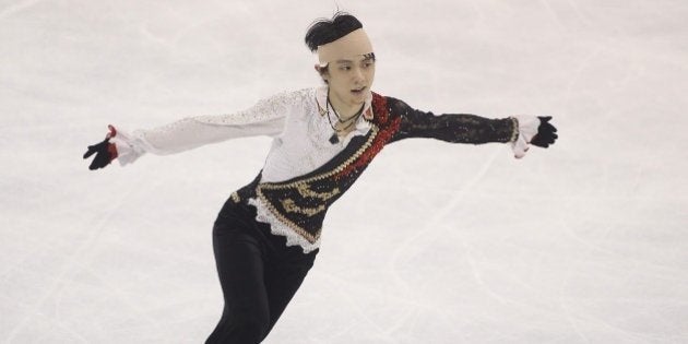 Japanese skater Yuzuru Hanyu, seen wearing a bandage to his head after colliding with Yan Han of China during an earlier practice session, performs during his men's free skating event of the Cup of China ISU Grand Prix of Figure Skating in Shanghai on November 8, 2014. AFP PHOTO CHINA OUT (Photo credit should read STR/AFP/Getty Images)