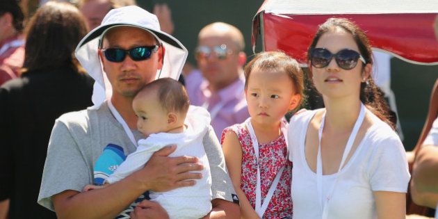 MELBOURNE, AUSTRALIA - JANUARY 11: Michael Chang, coach of Kei Nishikori of Japan looks on with his wife Amber Liu and his children after Nishikoris match against Tomas Berdych of the Czech Republic in the final during day four of the AAMI Classic at Kooyong on January 11, 2014 in Melbourne, Australia. (Photo by Scott Barbour/Getty Images)