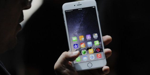 An attendee demonstrates the new Apple Inc. iPhone 6 Plus after a product announcement at Flint Center in Cupertino, California, U.S., on Tuesday, Sept. 9, 2014. Apple Inc. unveiled redesigned iPhones with bigger screens, overhauling its top-selling product in an event that gives the clearest sign yet of the company's product direction under Chief Executive Officer Tim Cook. Photographer: David Paul Morris/Bloomberg via Getty Images