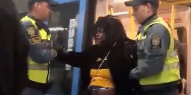 警備員によって地下鉄の電車から降ろされる女性