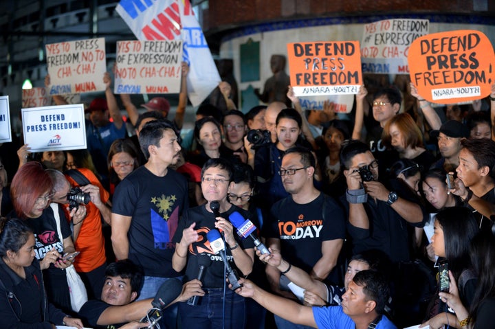 This file photo taken on January 19, 2018 shows Maria Ressa (C-with microphone), the CEO and editor of online portal Rappler, speaking during a protest on press freedom along with fellow journalists in Manila.