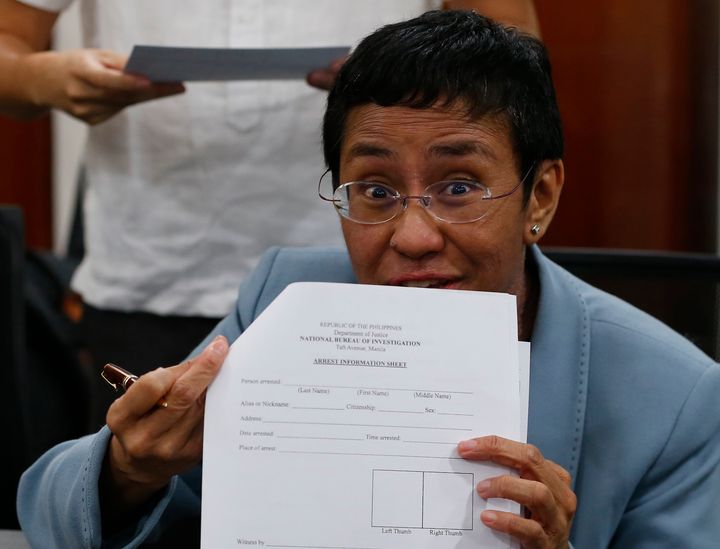 Maria Ressa shows an arrest form after being arrested by National Bureau of Investigation agents in a libel case on Feb. 13, 2019 in Manila, Philippines.