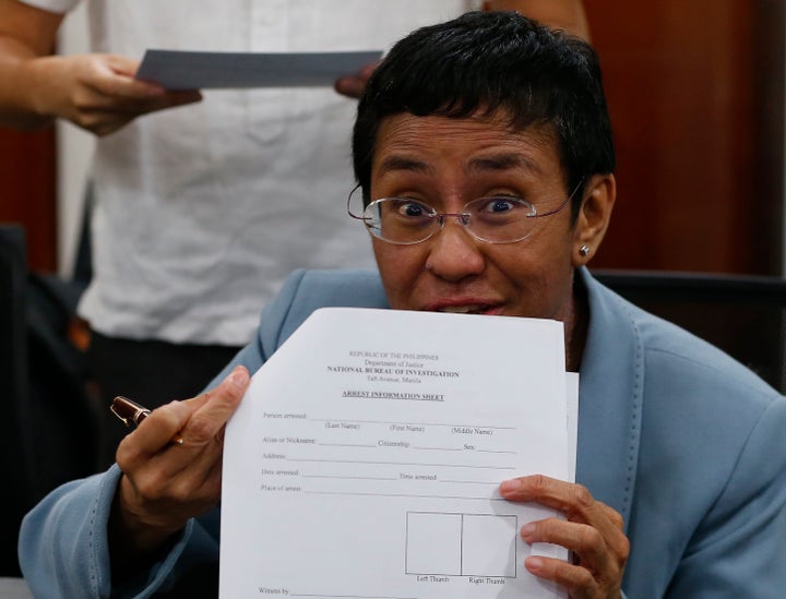 Maria Ressa shows an arrest form after being arrested by National Bureau of Investigation agents in a libel case on Feb. 13, 2019 in Manila, Philippines.