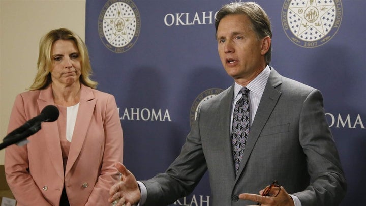 Republican Oklahoma Attorney General Mike Hunter, right, gestures as he speaks at a 2017 news conference about forming an opi