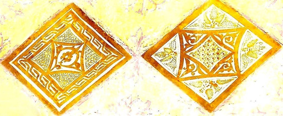 Gros plan sur deux carreaux de céramique lustrée à reflets métalliques dorés....