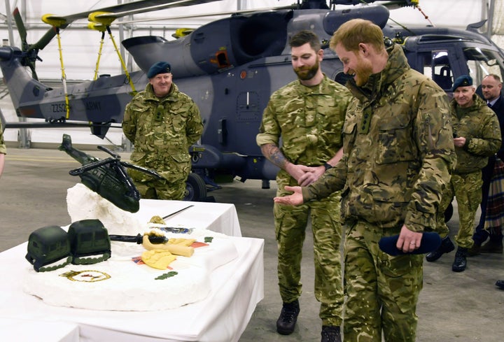 Harry checking out the cake made by British and Norwegian troops. 