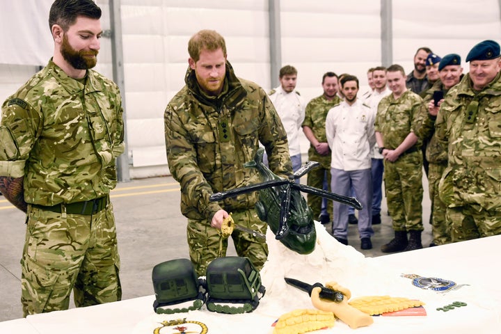 Slicing said cake with a sword. 