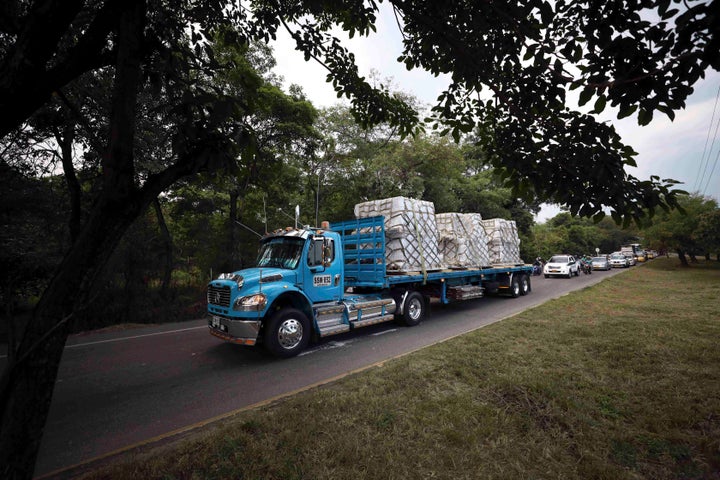 Trucks loaded with USAID humanitarian aid for Venezuela are escorted by police as they arrive at the Tienditas International