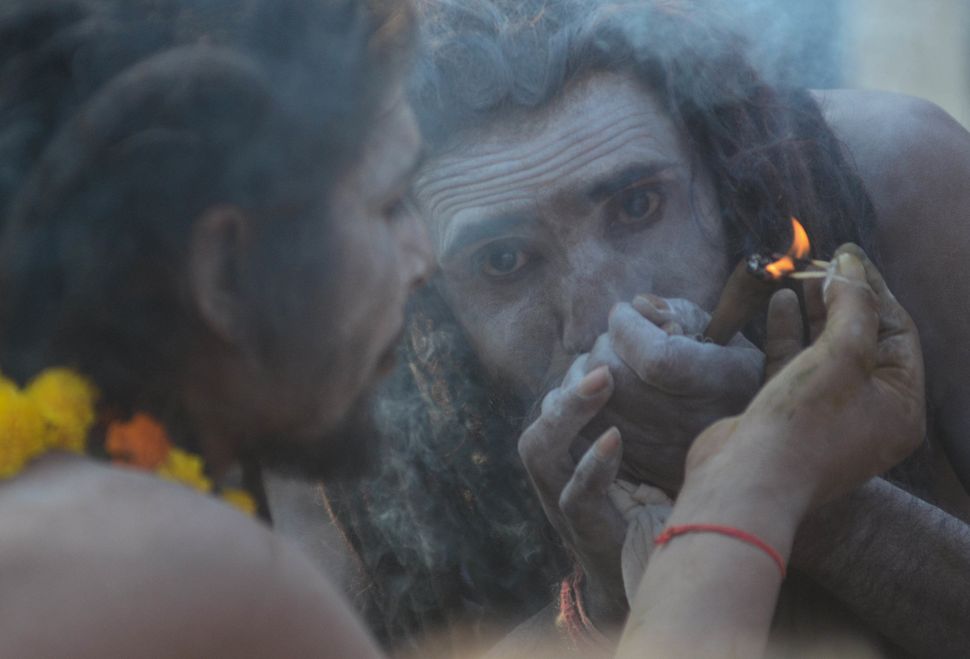 A sadhu of Juna Akhara smokes marijuana in Allahabad on December 25, 2018 .