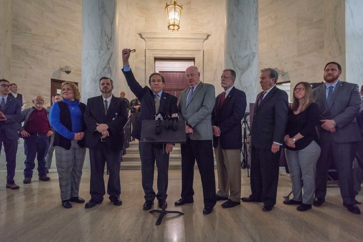 With his fist raised, Fred Albert, president of the American Federation of Teachers-West Virginia, joins other union leaders in a call for a statewide strike beginning Tuesday.