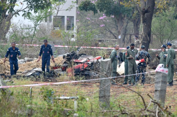 Indian Air Force personnel gather around the wreckage of one Surya Kiran 'Hawk' aircraft after two of them collided in mid-air and crashed during India's biennial international Air Show rehearsal at the Yelahanka Air Force Station in Bangalore on February 19, 2019. 