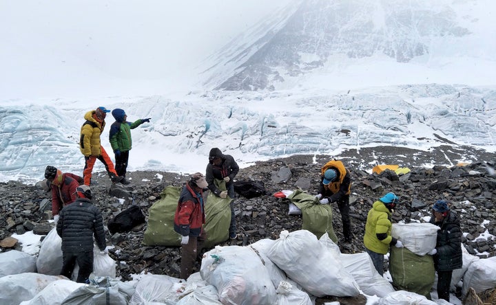 In this May 8, 2017, file photo released by Xinhua News Agency, people collect garbage at the north slope of Mount Everest in southwest China's Tibet Autonomous Region.