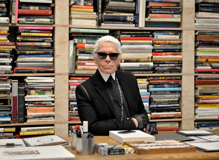 Karl Lagerfeld poses for photographers in front of his books prior to the start of an exhibition at the museum Folkwang in Essen, Germany, on Feb. 14, 2014.