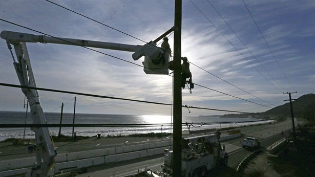 Crews from Southern California Edison work on damaged power lines. The utility and several others in the state are required to switch to time-of-use pricing, which charges more when electricity is costlier to produce.