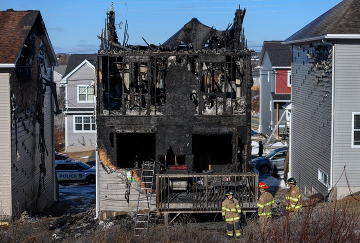 Firefighters investigate a house fire in the Spryfield community in Halifax, Nova Scotia, that claimed the lives of seven chi