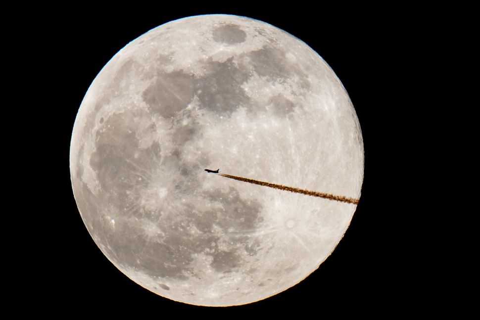 An airplane is seen against the supermoon on Feb. 19, in a photo taken from Nuremberg, southern Germany.