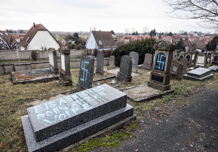 Vandalized tombs tagged with swastikas are pictured in the Jewish cemetery of Quatzenheim, in eastern France, on Feb.19, 2019