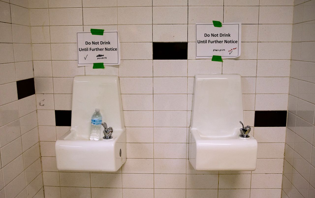 Water fountains with signs warning against drinking from them at a high school in Flint, Michigan, in May 2016. In 2014 the city changed its water source, resulting in lead contamination that persisted for more than a year. 