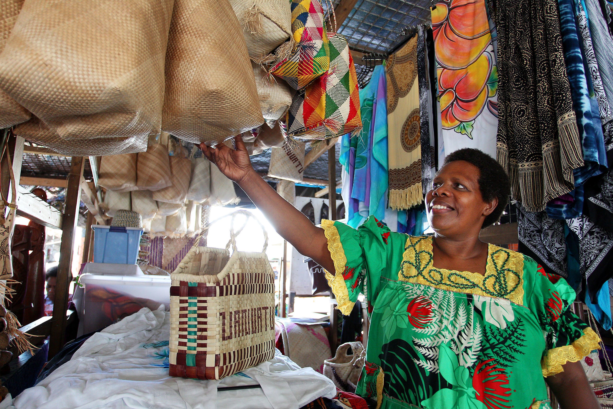 Rebecca Bula, a member and former vice president of a local handicraft cooperative, stands at her stall at the Port Vila mark