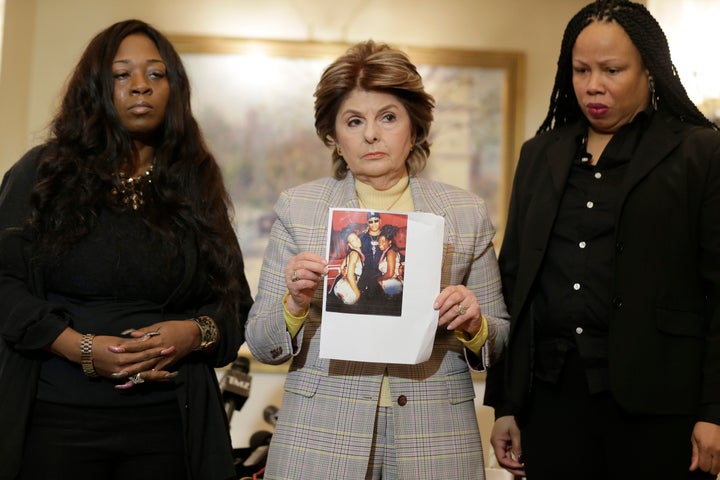 Latresa Scaff (R) and Rochelle Washington (L) look on as attorney Gloria Allred holds up a picture of them as teenagers on the night they claim they became victims of musician R. Kelly's sexual advances. The two women spoke out during a news conference in New York, on Thursday, Feb. 21, 2019.