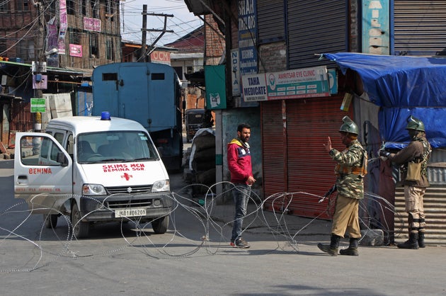Paramilitary soldiers stop an ambulance driver during restrictions in old city Srinagar, Kashmir on February...