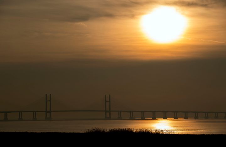 The sun sets behind the M4 Prince of Wales bridge near Bristol, as much of the country enjoys a weekend of unseasonably warm weather.