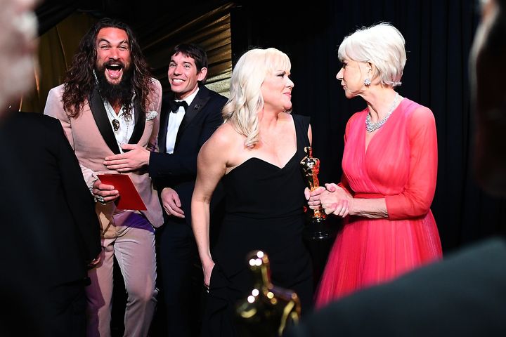 Ο Τζέισον Μομόα σκασμένος στα γέλια, ενώ η dame Ελεν Μίρεν (δεξιά) συνομιλεί με τη Σάνον Ντιλ,, παραγωγό του«Free Solo» που έλαβε το Όσκαρ στην κατηγορία Ντοκιμαντέρ Μεγάλου Μήκους. Μομόα και Μίρεν, το απόλυτα ετερόκλητο «ζευγάρι» παρουσιαστών.