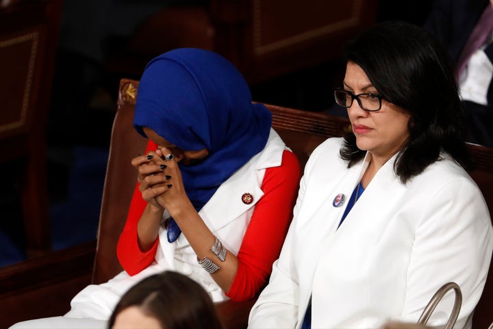 Rep. Ilhan Omar, D-Minn., left, and Rep. Rashida Tlaib, D-Mich., right, listen as President Donald Trump delivers his State o