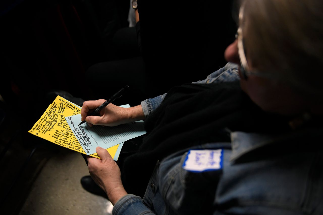 Ammertte Deibert, 70, of Ames, Iowa, jots down notes as she listens to Harris, former Colorado Gov. John Hickenlooper and former HUD Secretary Julián Castro at the Story County Democrats Soup Supper on Feb. 23.