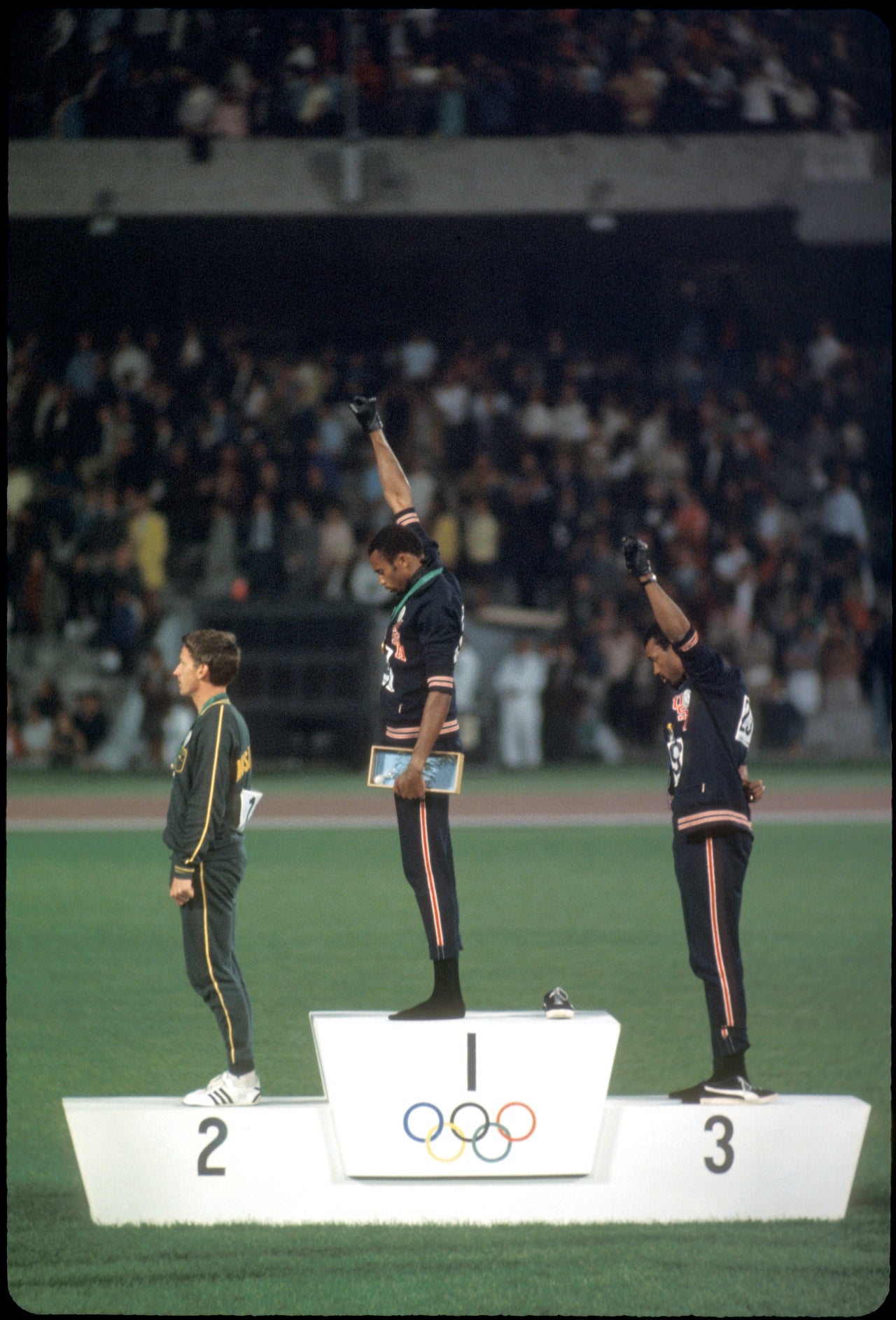 Tommie Smith and John Carlos raise their fists in a demonstration against American racism during the 1968 Olympic games.