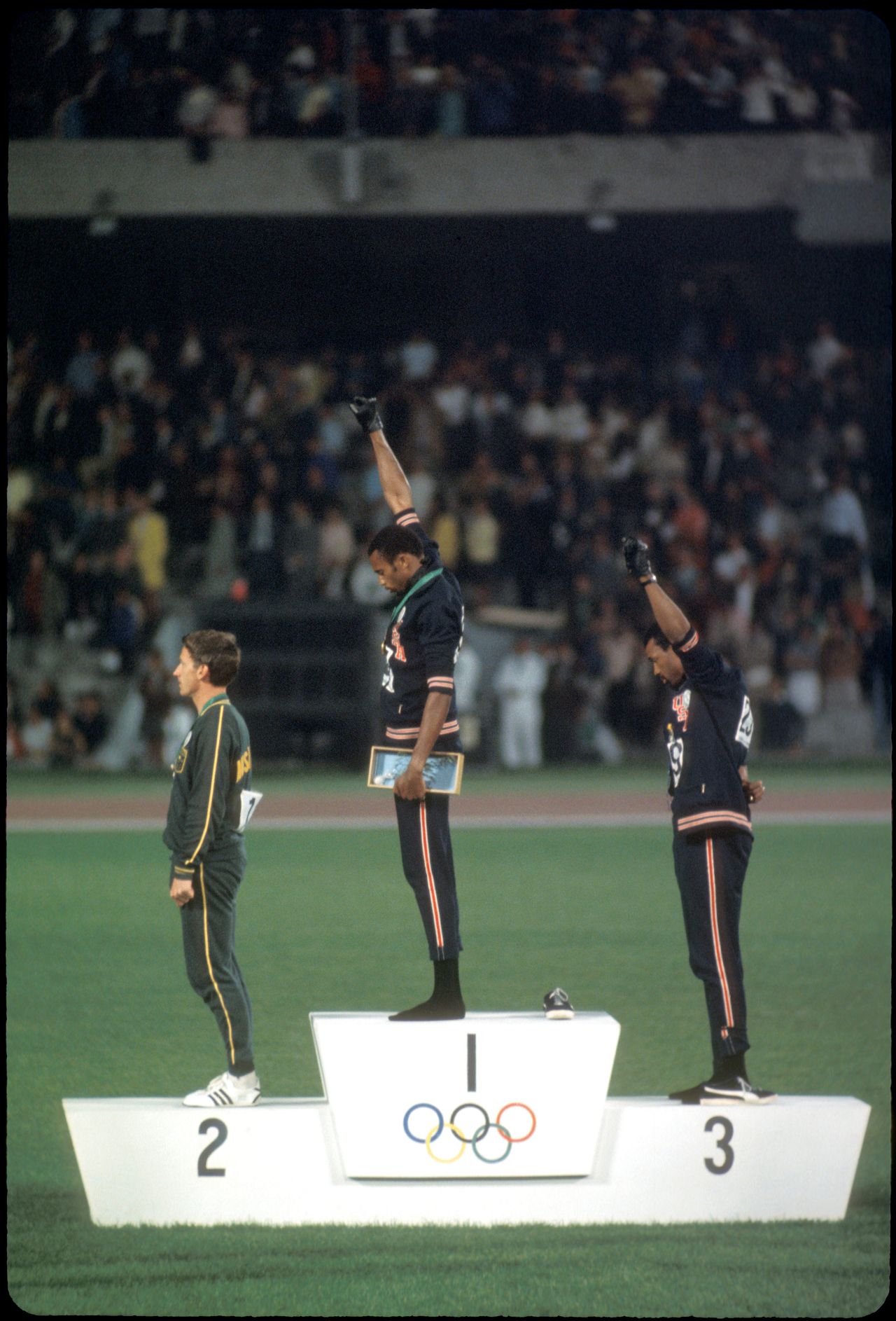 Tommie Smith and John Carlos raise their fists in a demonstration against American racism during the 1968 Olympic games. 