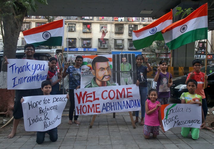 Children hold banners and Indian national flags after Imran Khan said Pakistan will release the Indian Air Force pilot.