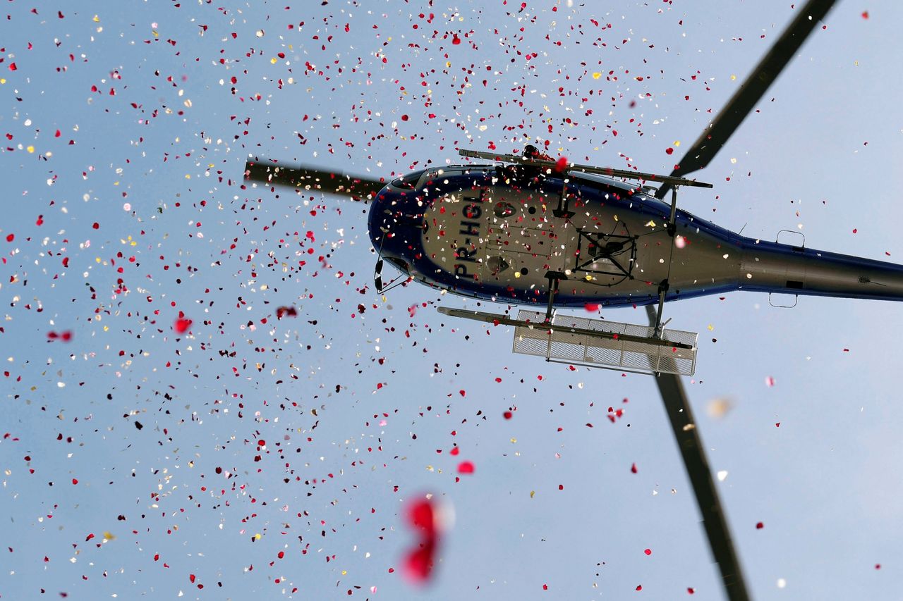 A helicopter showers flowers in honor of victims of the collapse of a dam owned by Brazilian mining company Vale SA, in Brumadinho, Brazil on Feb. 25, 2019.
