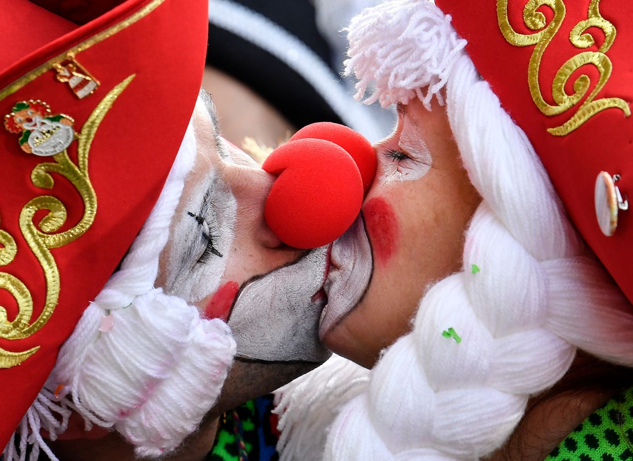Two revelers kiss for photographers as thousands dressed in costumes celebrate the start of the street carnival in Cologne, Germany, on Feb. 28, 2019.