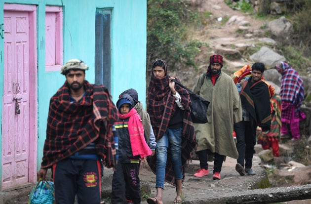 Refugees arrive at a community relief camp carrying personal belongings, after hundreds flee their home,...