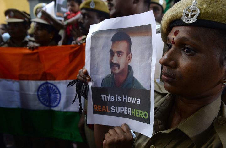 Indian security personnel carrying a picture of Wing Commander Abhinandan Varthaman on the day of his release