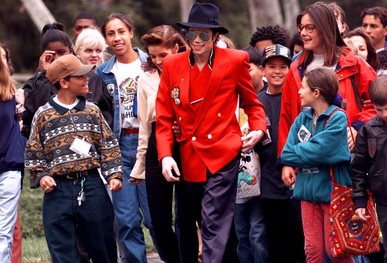 Michael Jackson and his then-wife Lisa Marie Presley, giving children a tour of his Neverland ranch in 1995.